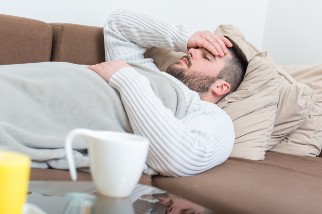 Man with flu resting on couch 