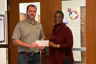 ASSP Central Indiana Chapter President Jeff Fox presents Dean Johns, chief program officer of John Boner Neighborhood Centers, with a donation to help low-income families in the community