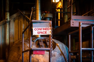 A sign on an industrial work site that says confined space