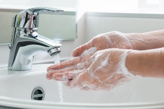 Person washing their hands in the sink