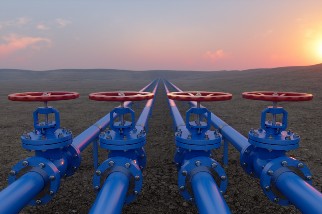 Gas transportation with blue gas or pipeline valves on soil with a sunrise background