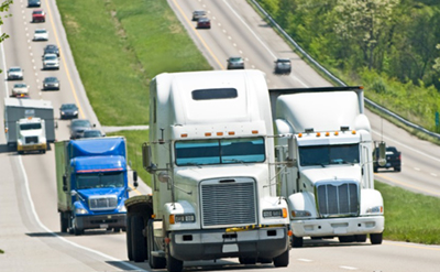 Semi trucks and vehicles traveling on divided four-lane highway