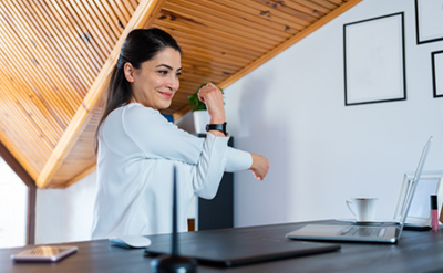 Woman stretching while working at home at stand-up desk