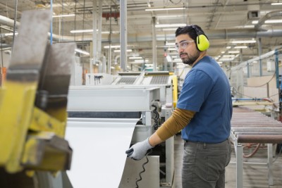 Factory worker wearing eye and ear protection 