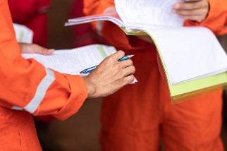 Two workers holding documents during an operational meeting