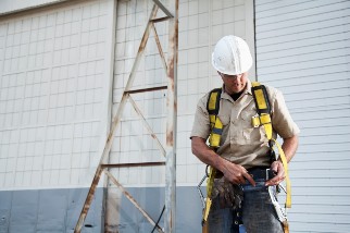 Worker donning a fall protection harness