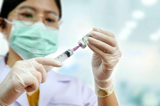 Doctor filling a syringe