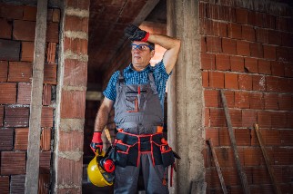 Construction worker wiping sweat from his forehead