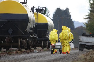 Workers handling hazardous materials near freight train