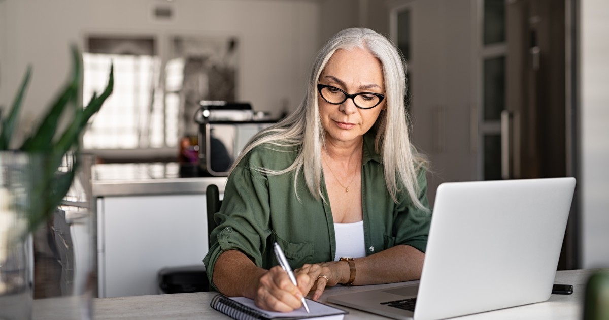 Safety professional middle aged woman with long hair and glasses attending a webinar at home on her laptop