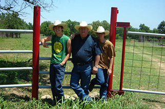Men stand in front of fence