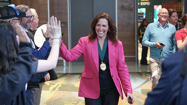 Image of ASSP President Linda Tapp greeting people with a high five outside the Safety 2025 General Session venue