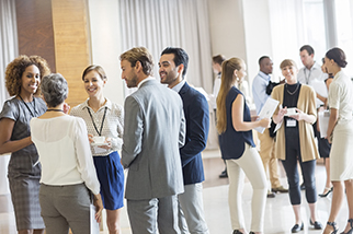 Group of business people standing in hall, smiling and talking together - stock photo